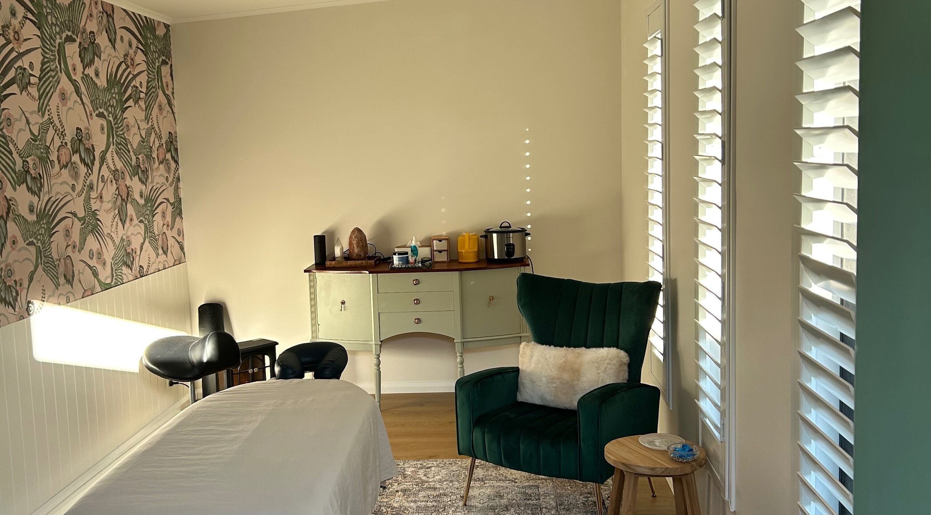 Relaxing space at Absolute Health and Harmony, Berkeley Vale, New South Wales, AU, with a massage bed and cozy chair.