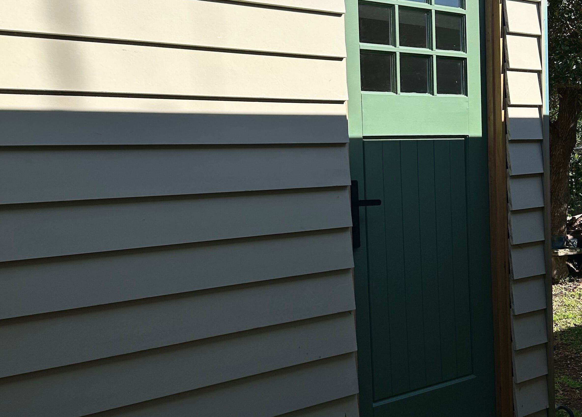 Entrance of Absolute Health and Harmony at Berkeley Vale, New South Wales, AU with green door and sunny facade.