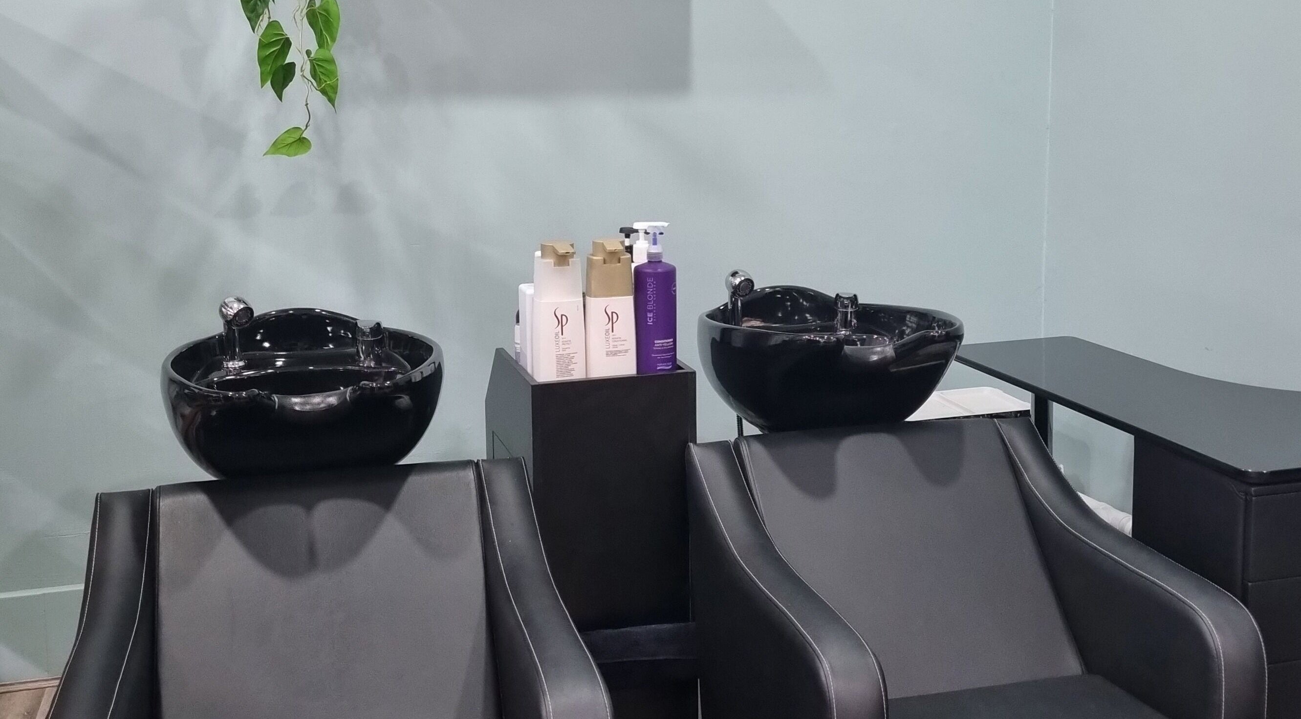 Elegant wash stations at Hair Majesty, Riverton, Western Australia, AU, featuring sleek black basins and chairs.