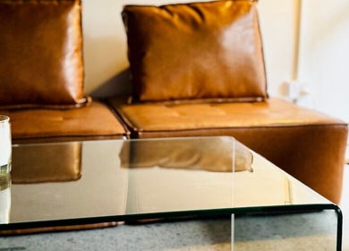 Elegant seating area with leather chairs and candle at Abōde, Sydney, New South Wales, AU.