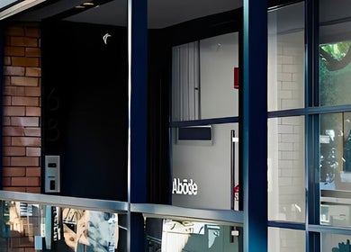 Entrance of Abōde, a chic beauty venue in Sydney, New South Wales, AU, showcasing sleek glass and brick design.