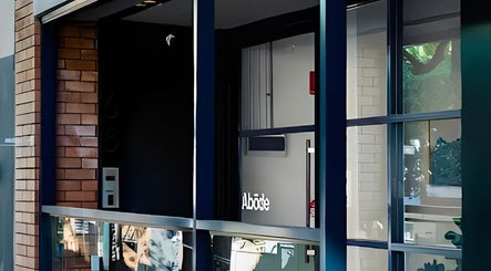 Entrance of Abōde, a chic beauty venue in Sydney, New South Wales, AU, showcasing sleek glass and brick design.
