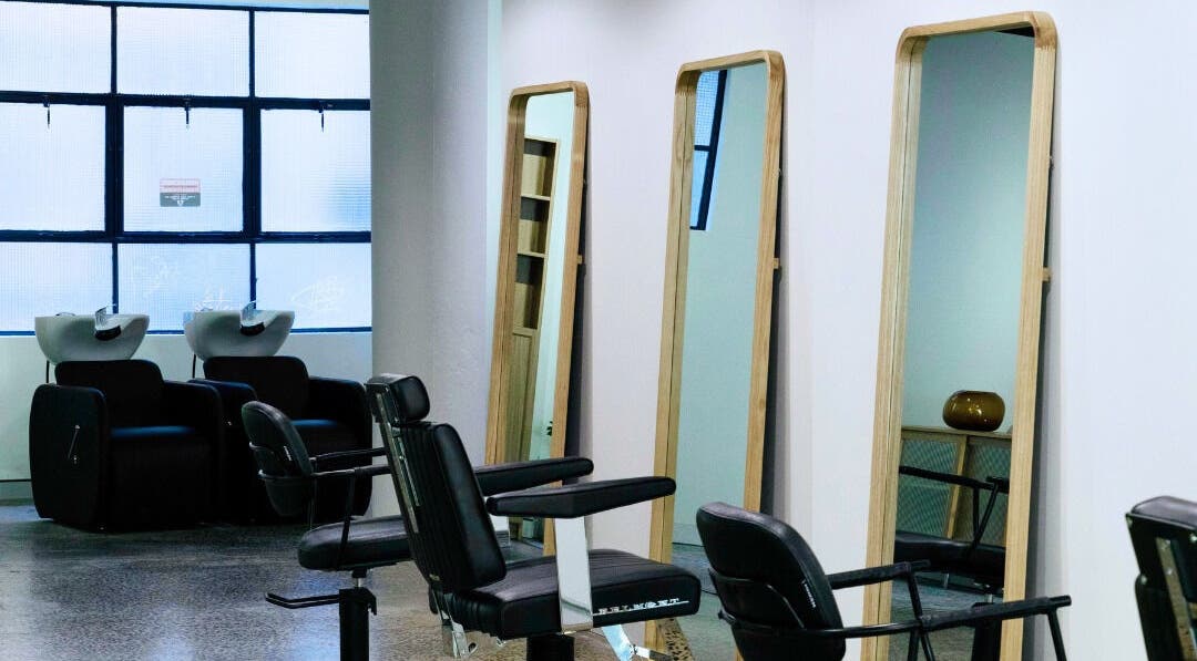 Modern salon at Abōde, Sydney, New South Wales, AU with stylish chairs and mirrors for clients.