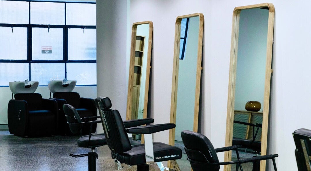Modern salon at Abōde, Sydney, New South Wales, AU with stylish chairs and mirrors for clients.
