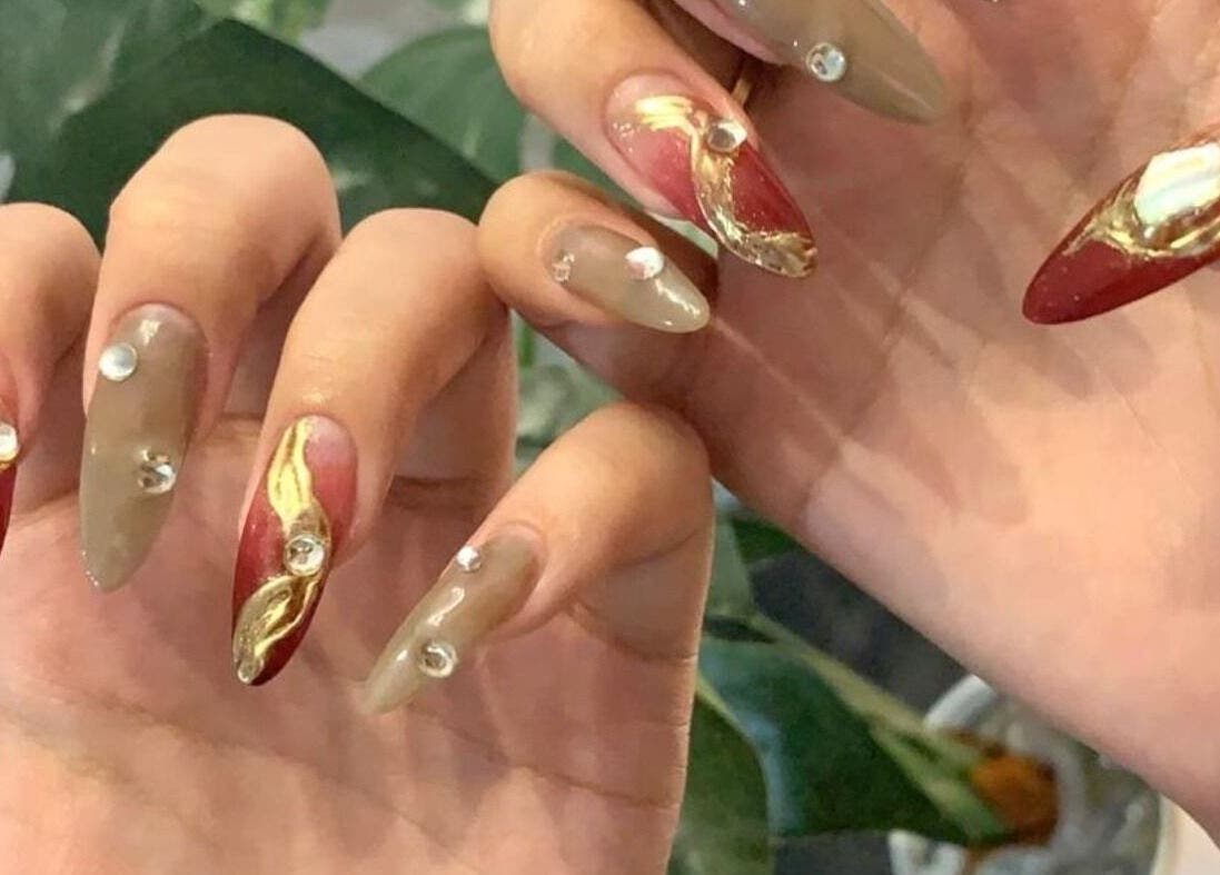 Intricate nail art featuring gold and red accents at Christine Nail Academy By Gaga& Co, Kuala Lumpur, MY.