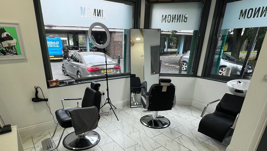 Modern salon interior at Binnom Hair, Newcastle upon Tyne, England, GB with styling chairs and large windows.