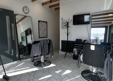 Modern interior of Binnom Hair salon in Newcastle upon Tyne, England, showcasing sleek chairs and mirrors.