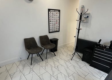 Modern waiting area at Binnom Hair, Newcastle upon Tyne, England, GB, featuring stylish chairs and sleek decor.