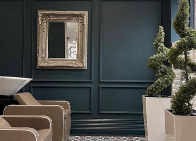 Elegant interior of Eve Woods Hair in Harrogate, England, GB with sleek chairs and decorative mirror.