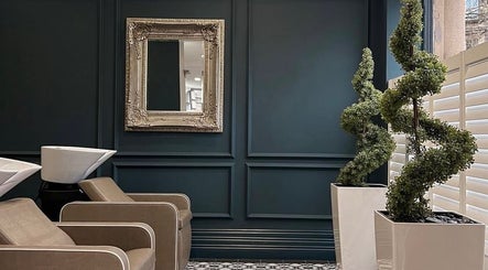 Elegant interior of Eve Woods Hair in Harrogate, England, GB with sleek chairs and decorative mirror.