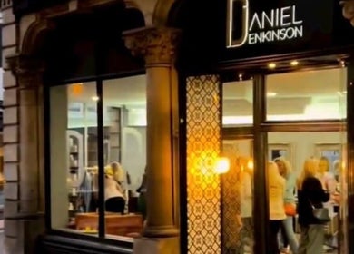 Eve Woods Hair in Harrogate, England, GB, showcasing a stylish, illuminated storefront with clients inside.
