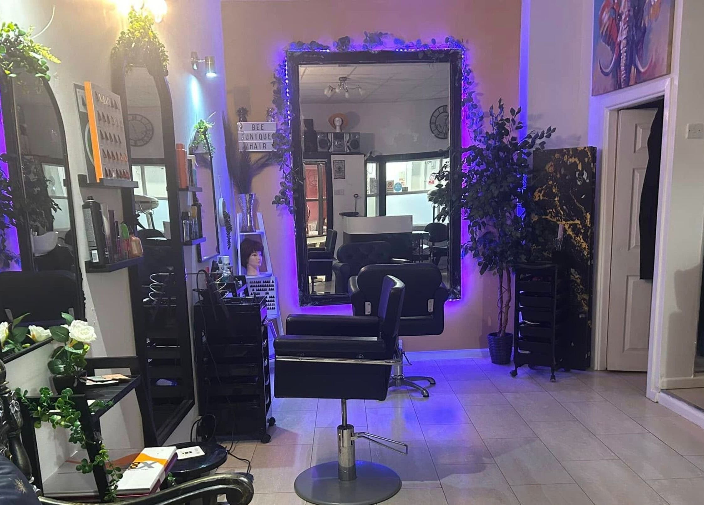 Modern beauty salon interior at BeeUnique, Northampton, England, GB, featuring stylish mirrors and seating.