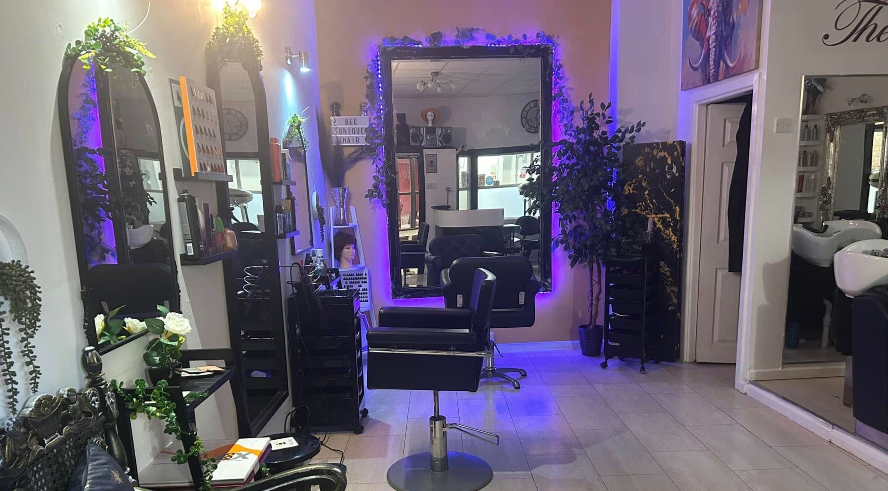 Modern beauty salon interior at BeeUnique, Northampton, England, GB, featuring stylish mirrors and seating.