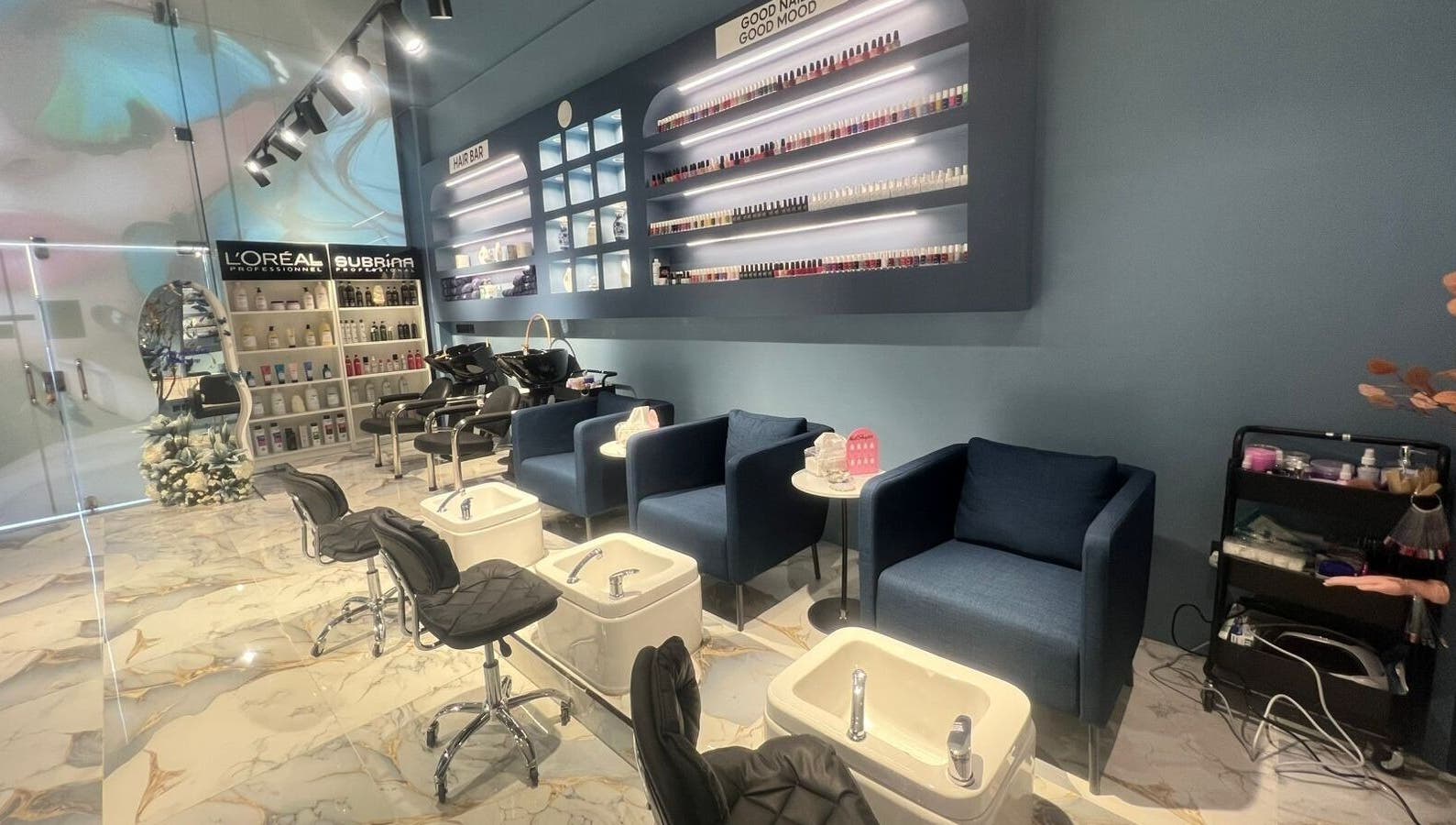 Elegant interior of 3 Papillons Salon in Dammam, Eastern Province, SA showcasing manicure stations and product displays.
