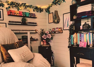 Relaxing therapy room at Marie Johnson Holistic Therapies, Crediton, England, GB, showcasing essential oils and books.