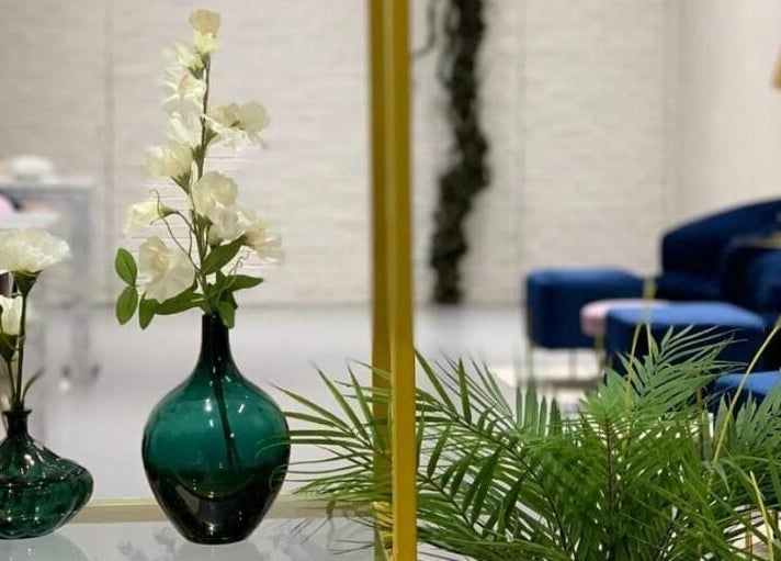 Elegant interior of Naqa Nails, Diriyah, Riyadh Province, SA with green vases and white flowers.