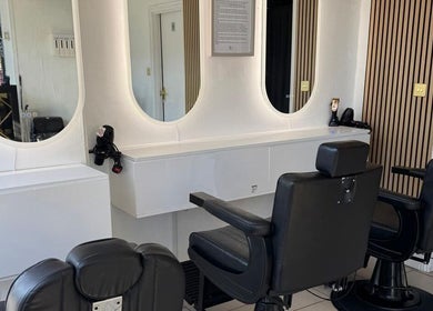 SEVEN Hair Studio in London, England, GB with sleek black chairs and stylish oval mirrors.