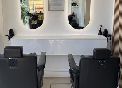 Stylish chairs at SEVEN Hair Studio, London, England, GB, reflected in sleek salon mirrors.