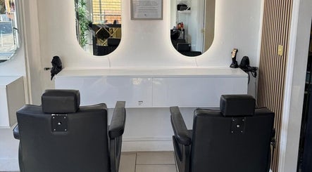 Stylish chairs at SEVEN Hair Studio, London, England, GB, reflected in sleek salon mirrors.