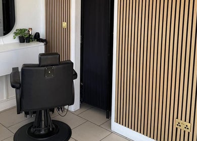 Modern salon chair and mirror at SEVEN Hair Studio, London, England, GB with elegant wood wall paneling.
