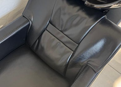 Modern black salon chair at SEVEN Hair Studio, London, England, GB offers comfort for beauty treatments.