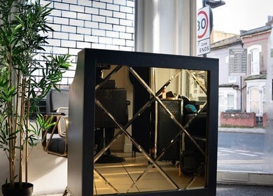 Entrance of SEVEN Hair Studio in London, England, GB, showcasing elegant reception decor with lush greenery.