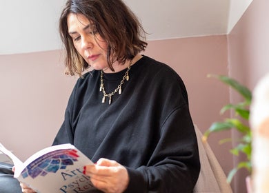 A woman reads a book in a calm setting at The Tides, Leeds, GB, symbolizing relaxation and mindfulness.