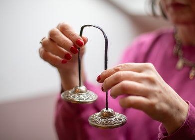 A person holding meditation chimes at The Tides, Leeds, GB, promoting relaxation and wellness.