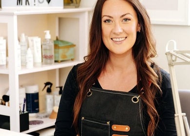 Nail artist smiling at Fleur’s Nails MK in Milton Keynes, England, GB, showcasing a welcoming salon environment.
