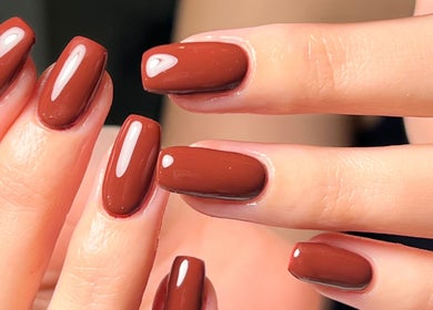 Elegant cocoa manicure at Fleur’s Nails MK in Milton Keynes, England, GB showcasing stunning glossy brown nails.