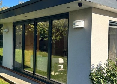 Modern garden view at Eden Beauty, Oxford, England, GB, featuring glass doors and lush greenery.