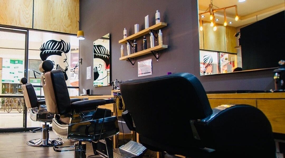 Interior del WOLFPACK Barber Shop and Beauty Salon en Ciudad de México, MX, con sillas de barbero elegantes.