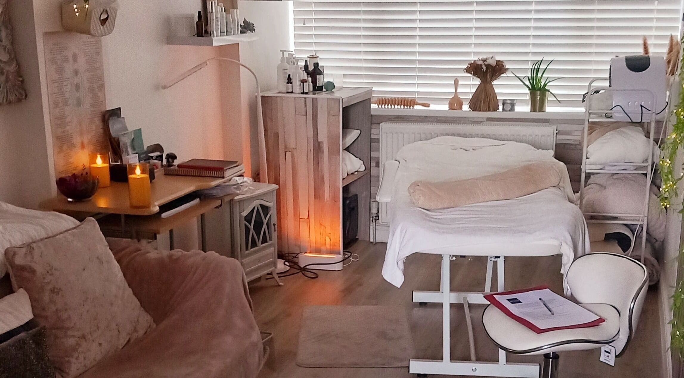 Cozy therapy room at HENYO Studio, BRIDGNORTH, England, GB, featuring a massage table, candles, and decor.