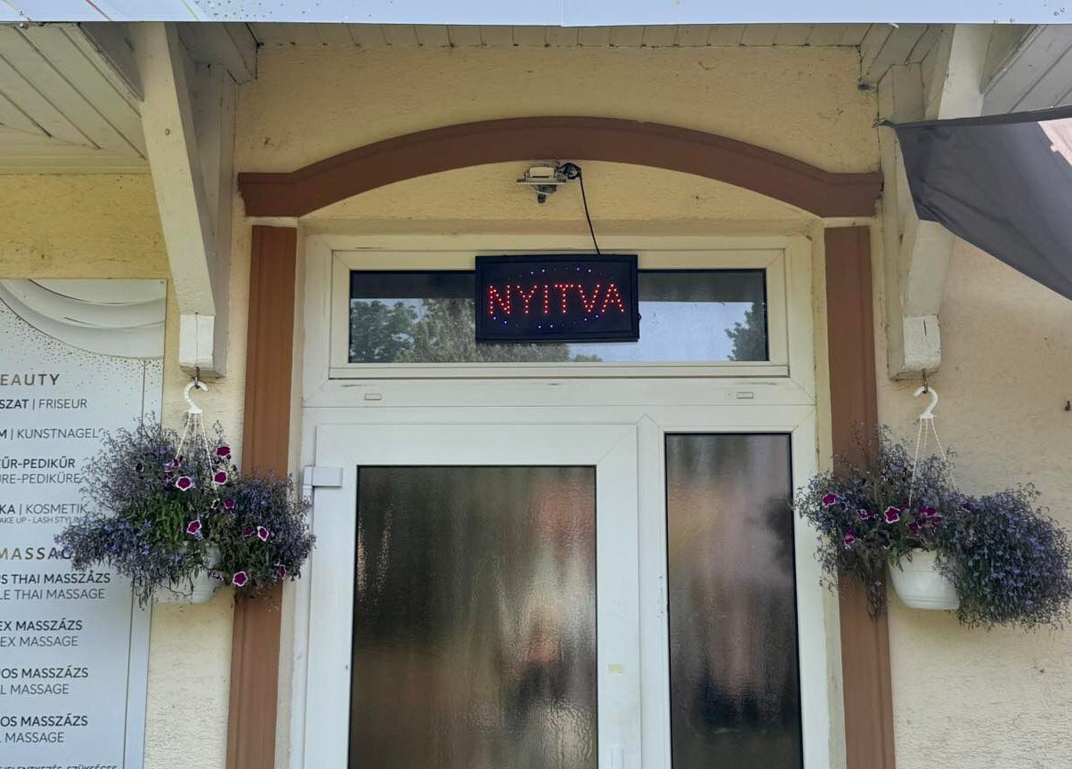 Terv utca 4. Menta Thai Massage bejárata Mosonmagyaróvár, HU-ban, nyitva jelzéssel és virágokkal.