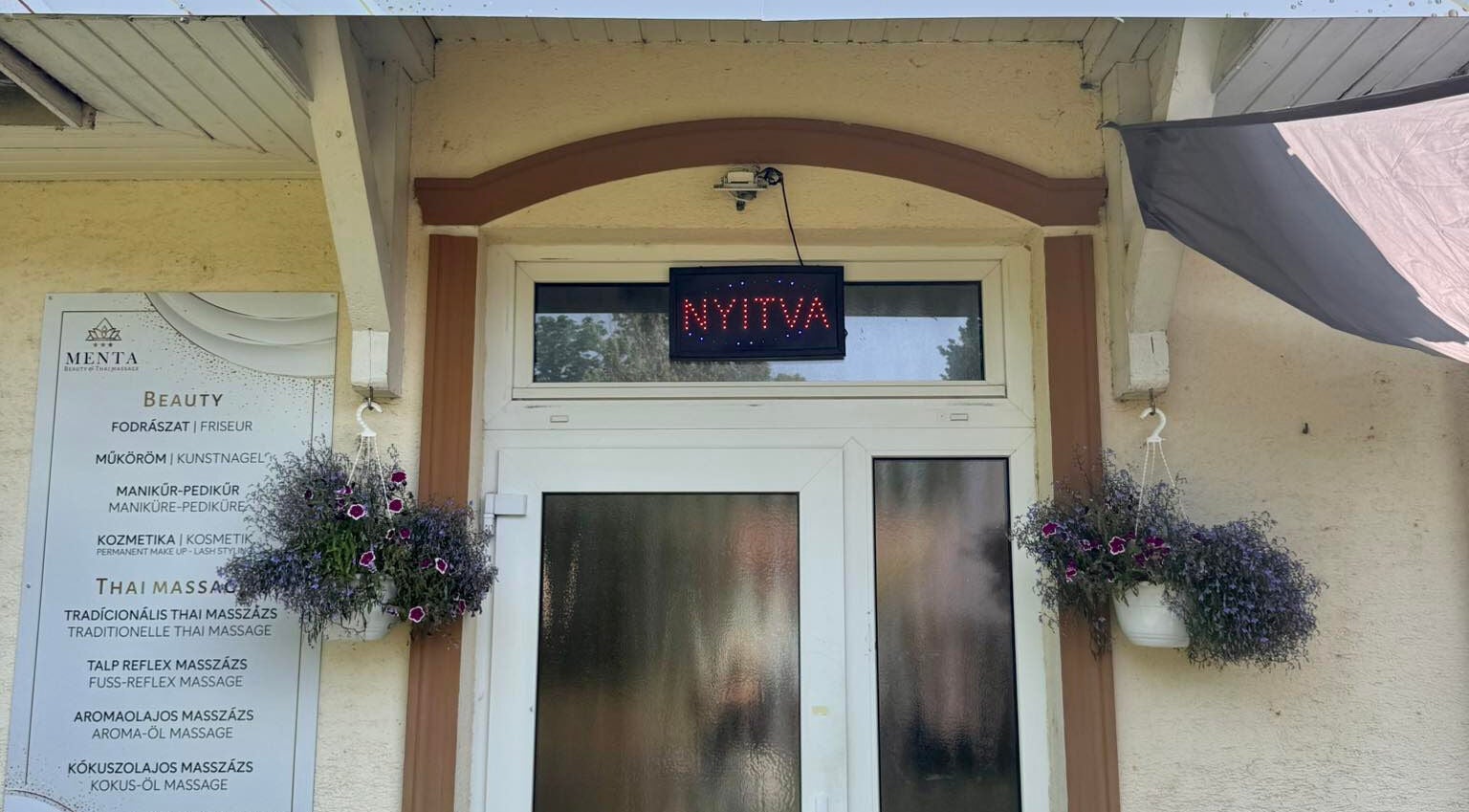 Terv utca 4. Menta Thai Massage bejárata Mosonmagyaróvár, HU-ban, nyitva jelzéssel és virágokkal.