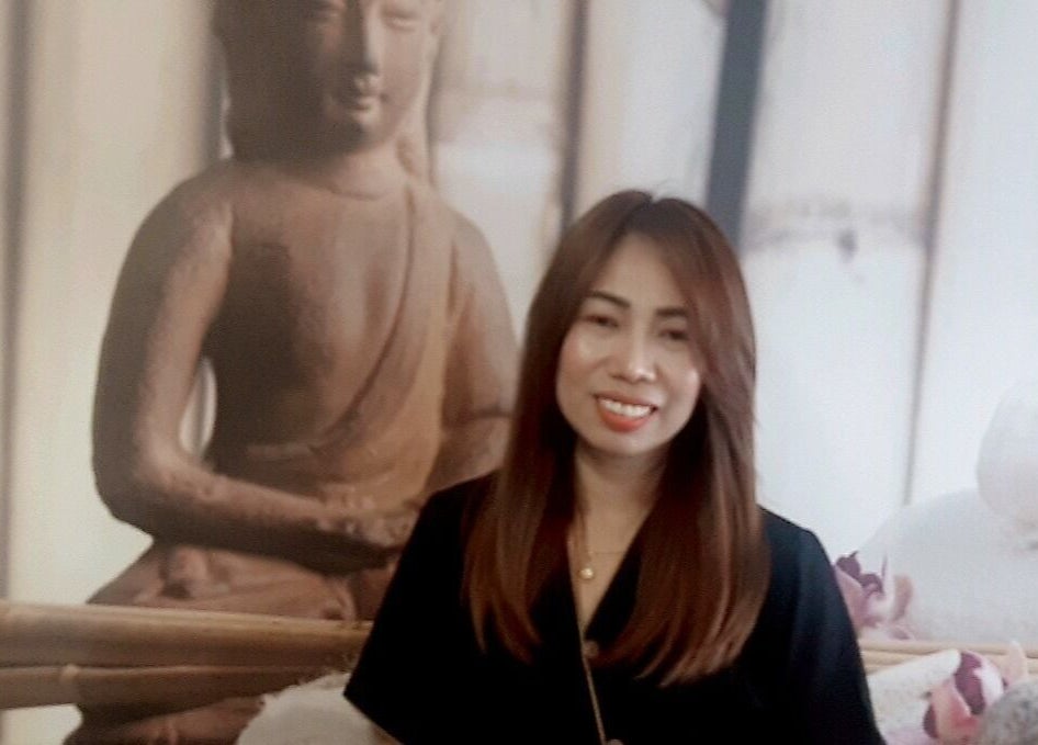 Mosolygós terapeuta Buddha szoborral a Menta Thai Massage, Mosonmagyaróvár 9200. Jókai utca 6. területén.