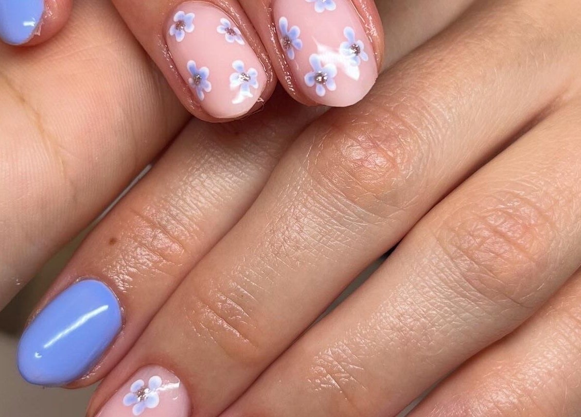 Floral nail art with blue accents at Clos Beauty, Peterborough, England, GB.
