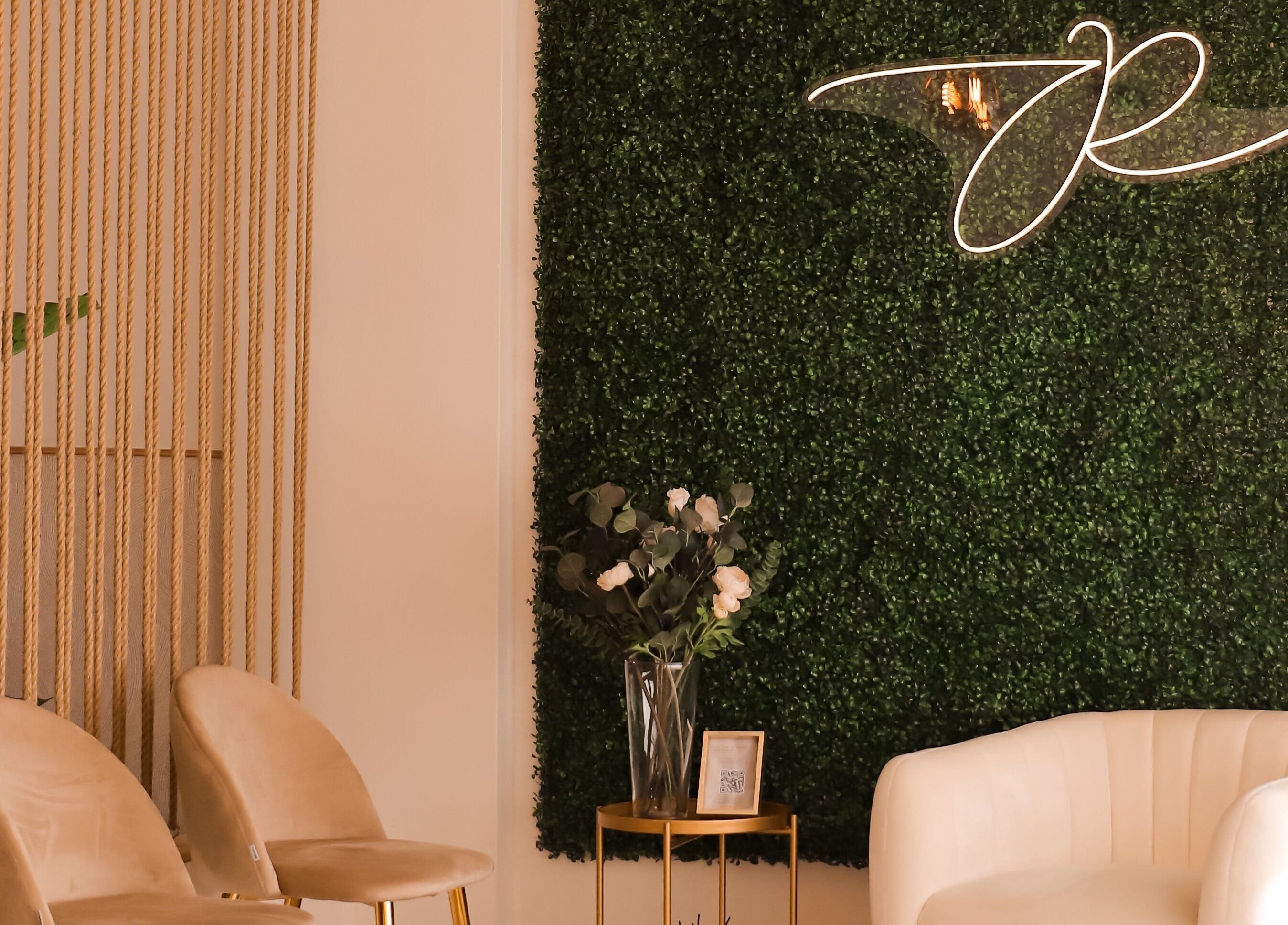 Interior acolhedor da JORA Aesthetics | Clinic & Academy em Braga, Braga, PT com parede verde e poltronas elegantes.