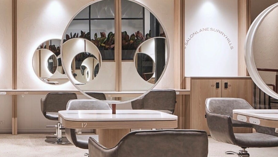 Modern salon interior at Sirens Hair Extensions, Campsie, New South Wales, AU, showcasing sleek design and mirrors.
