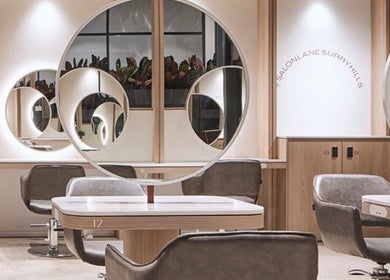 Modern salon interior at Sirens Hair Extensions, Campsie, New South Wales, AU, showcasing sleek design and mirrors.
