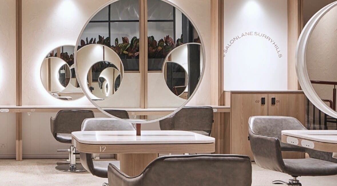 Modern salon interior at Sirens Hair Extensions, Campsie, New South Wales, AU, showcasing sleek design and mirrors.