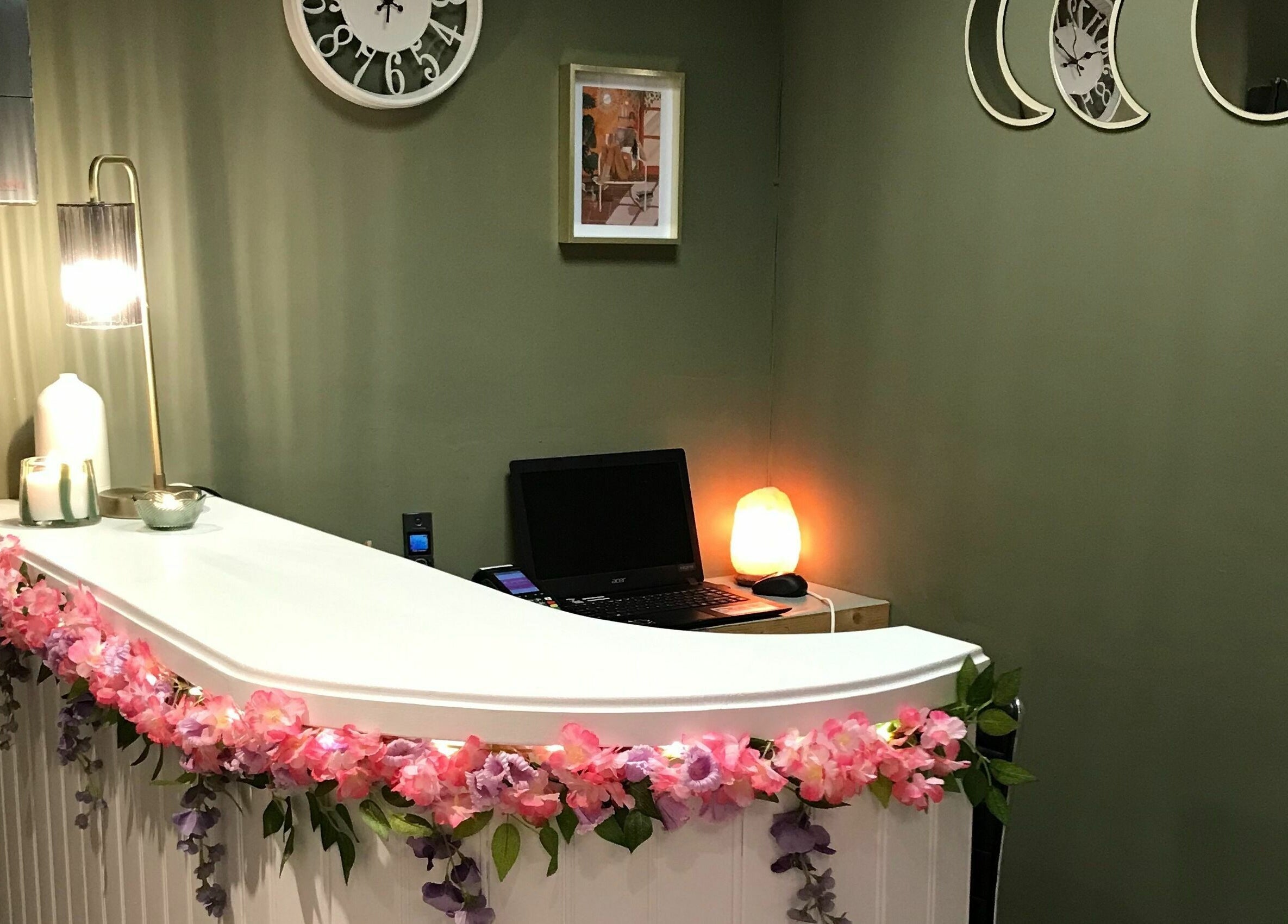 Wild Beauty reception desk adorned with pink flowers and soft lighting, Clifden, County Galway, IE.