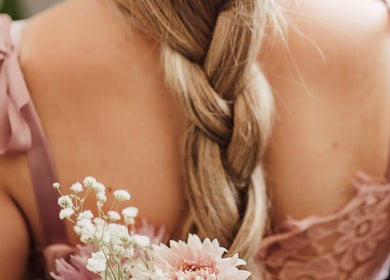 Elegant braided hairstyle with floral accents at CURA, Trail, British Columbia, CA.