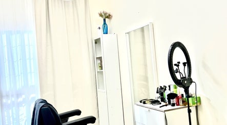 Calm salon interior at Just A Smile Salon, Doha, with styling chair, ring light, and products on a white cabinet.