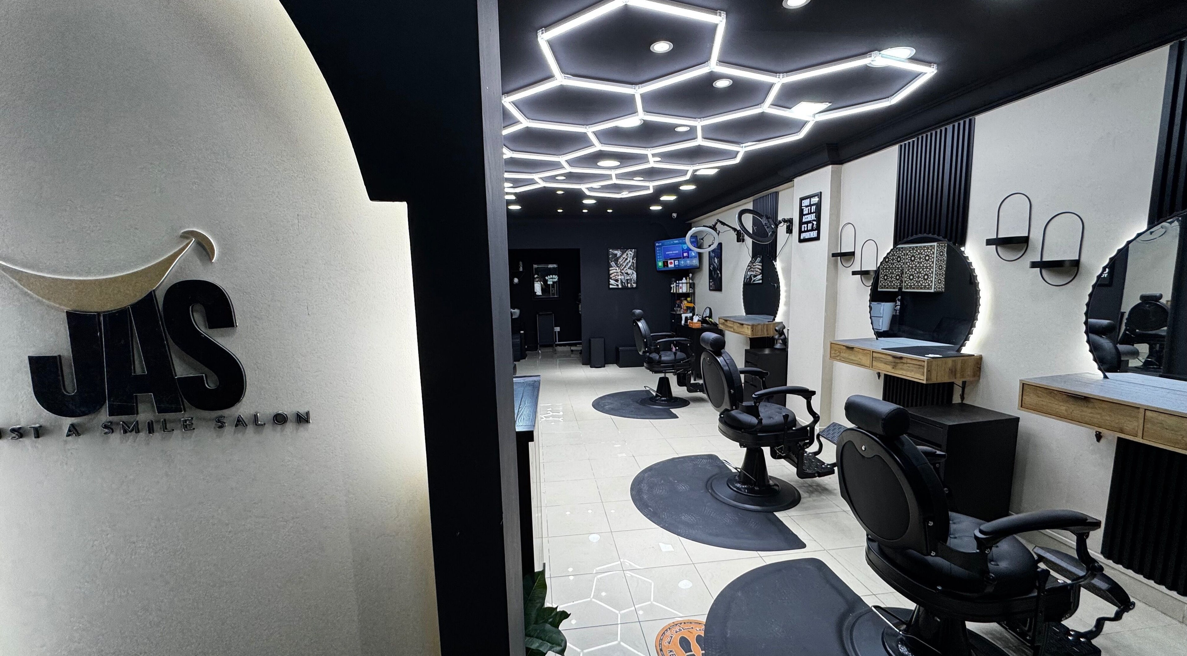 Spacious interior of Just A Smile Salon, Doha, Doha Municipality, QA with stylish modern lighting and salon chairs.