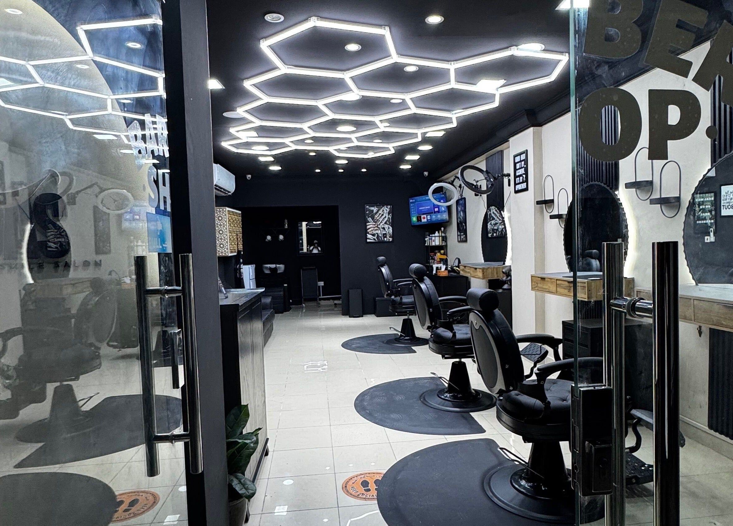 Modern barber chairs at Just A Smile Salon in Doha, Doha Municipality, QA, featuring stylish decor and lighting.