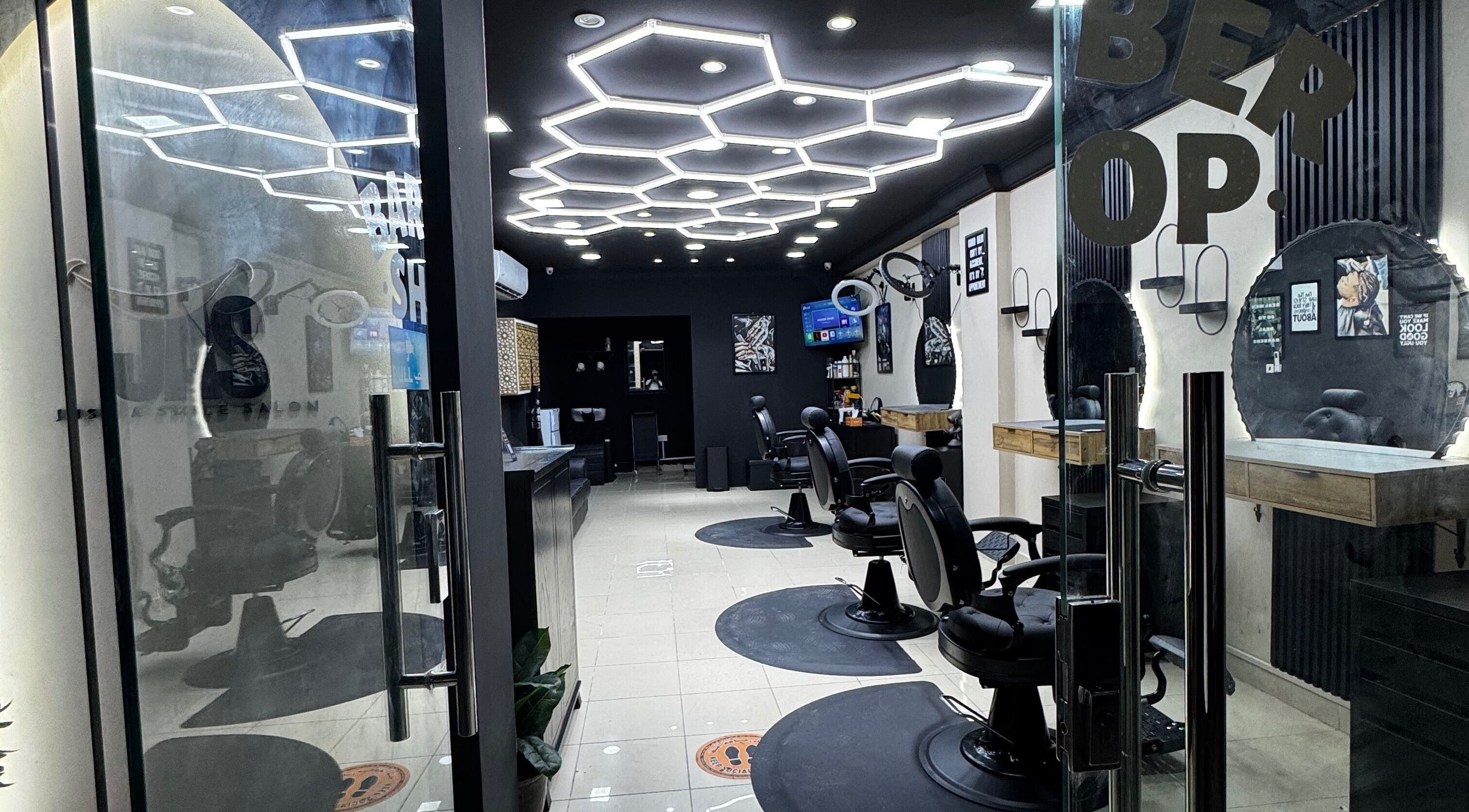 Modern barber chairs at Just A Smile Salon in Doha, Doha Municipality, QA, featuring stylish decor and lighting.