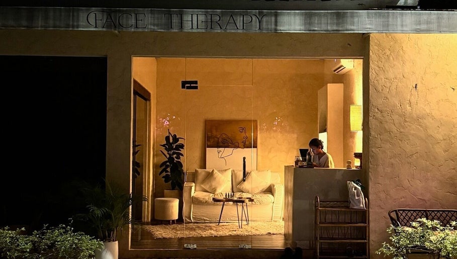 Warm-lit entrance of Face Therapy Spa, Umalas in Bali, ID, showcasing an inviting interior with cozy seating.