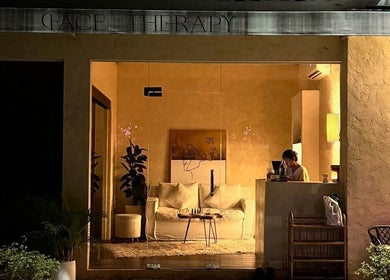 Warm-lit entrance of Face Therapy Spa, Umalas in Bali, ID, showcasing an inviting interior with cozy seating.