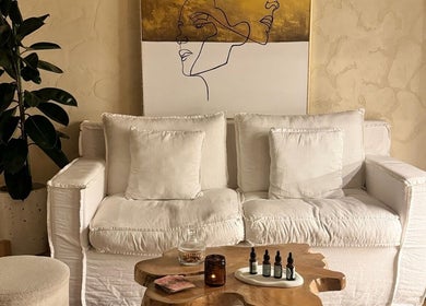 Calm lounge area at Face Therapy Spa, Umalas, Bali, ID with white sofa, art, and greenery for relaxation.